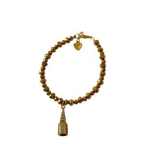 Gold beaded bracelet with building charm
